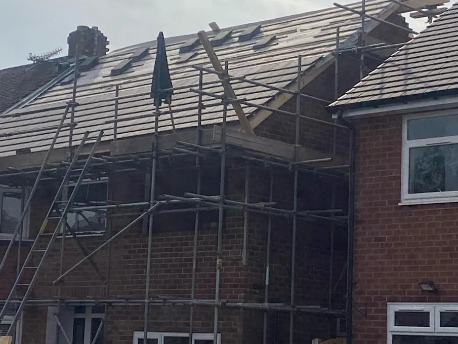 A house roof being re-covered behind a scaffold