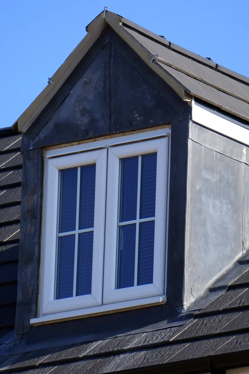 A slate roof with a lead-clad dormer window