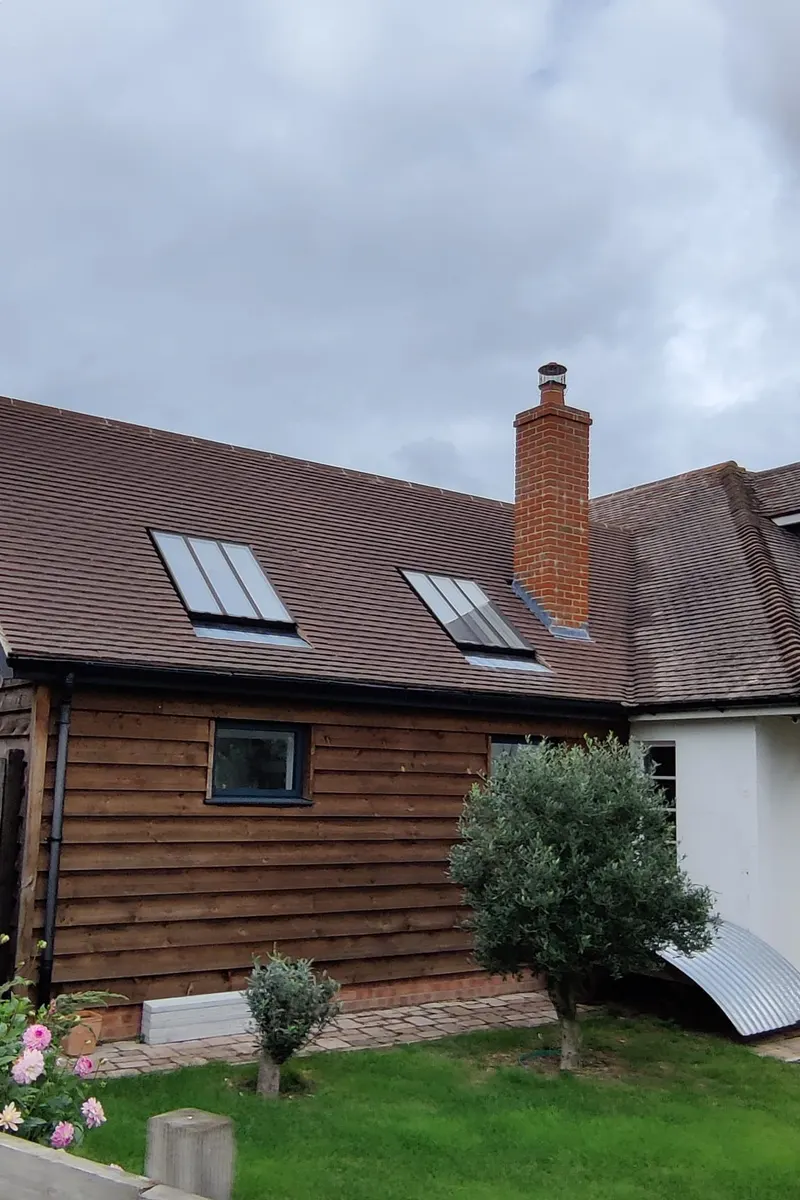 A dry ridge system along a grey tiled roof