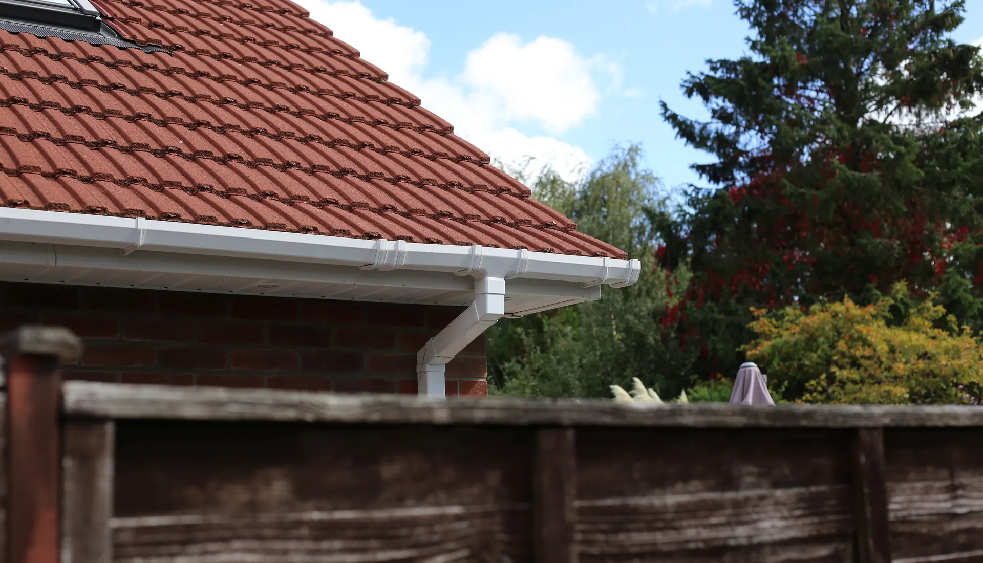 White guttering and a downpipe on a tiled house