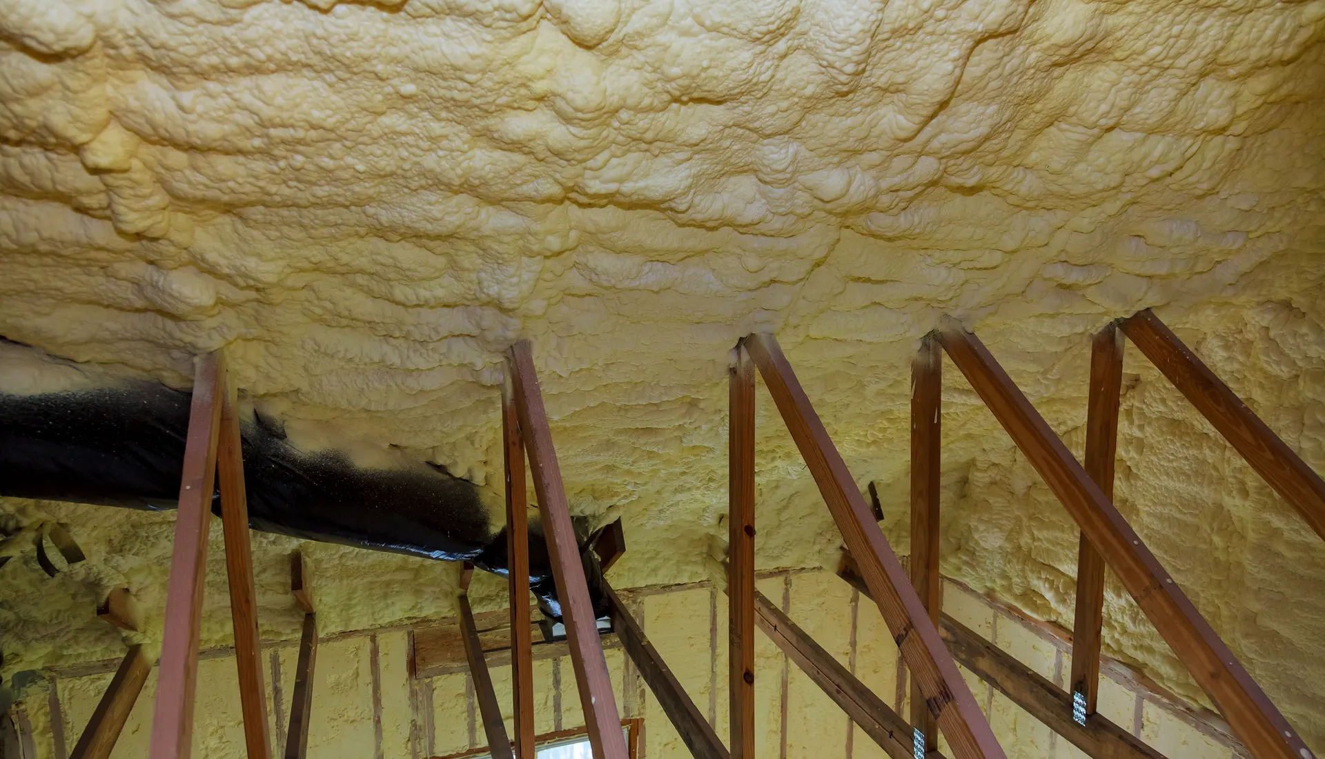 Spray foam insulation coating the underside of a roof
