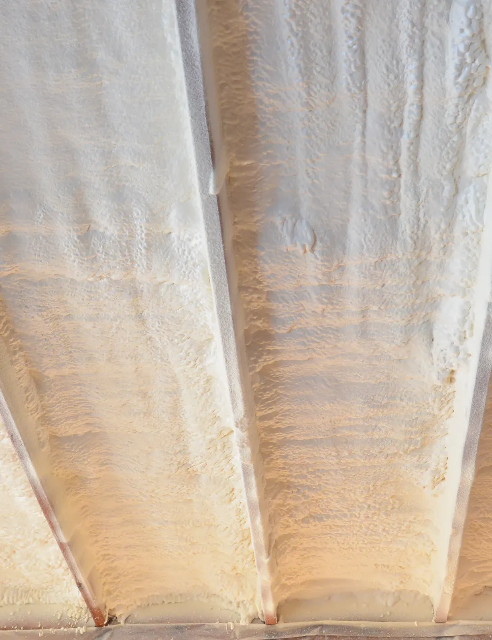 Spray foam covering the rafters and roof deck in a loft