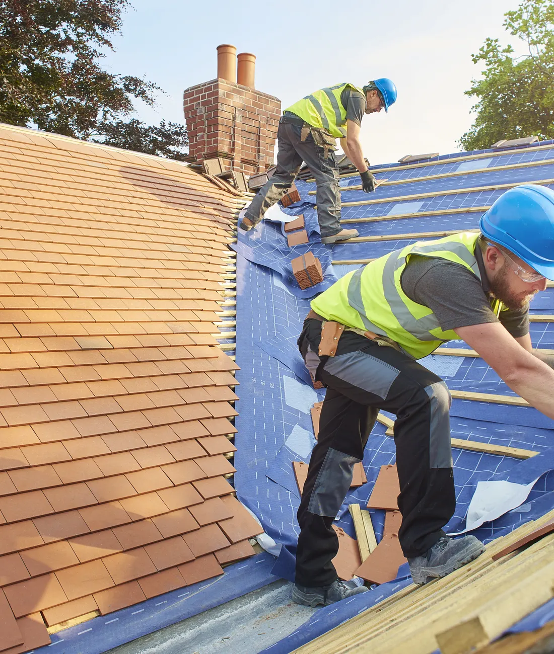 A roofer at work on a new tiled roof